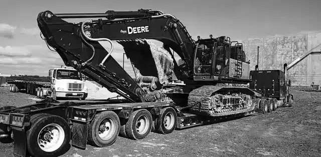 Excavator secured on a heavy equipment transport trailer