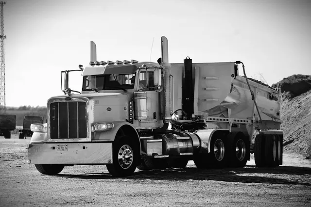 Tractor and dump trailer parked at a material site