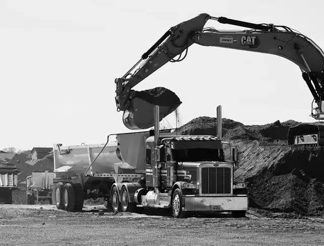 Excavator loading material into a hauling truck