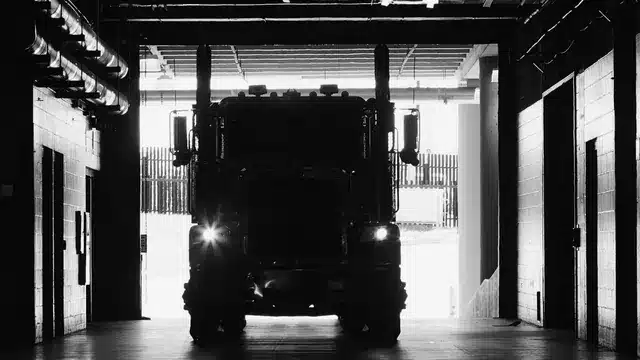 Truck positioned inside a material loading structure